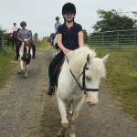 Young girl in black on white horse in County Antrim