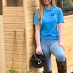 Girl standing beside wooden hut in County Antrim