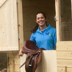 Girl smiling out window of a horse stable in County Antrim